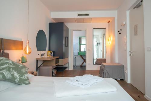 a bedroom with a white bed and a desk at Glocal Torbole in Nago-Torbole