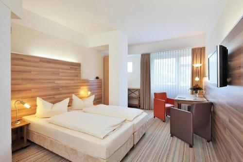 a hotel room with a bed and a desk at Petul Apart Hotel City in Essen