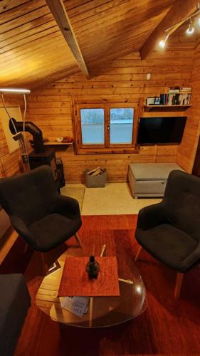 a living room with two chairs and a table at Holzhaus direkt am See in Priepert
