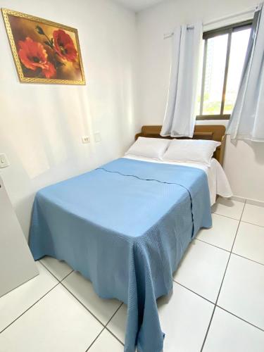 two beds in a room with a blue blanket at AP Evangelista in Caruaru