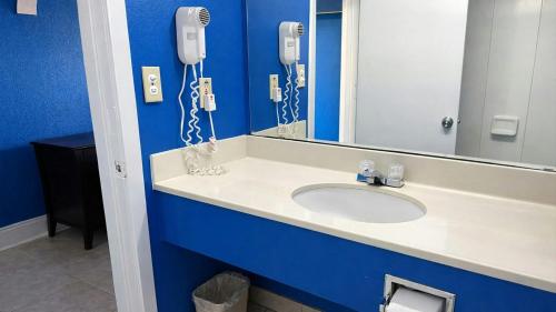 a bathroom with a sink with a mirror and phones at Apollo Lodge and RV Park in Fairfield