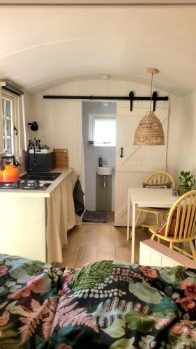 a kitchen and dining room with a table and a kitchen at Cwt Cen y Coed in Llanferres