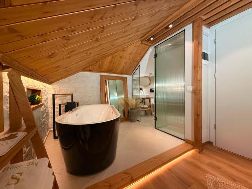 a large bath tub in a bathroom with wooden ceilings at The Stone Sky Hotel in Gjirokastër