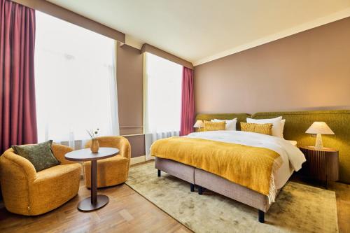 a hotel room with a bed and a chair at ARQ Paleis Hotel in The Hague