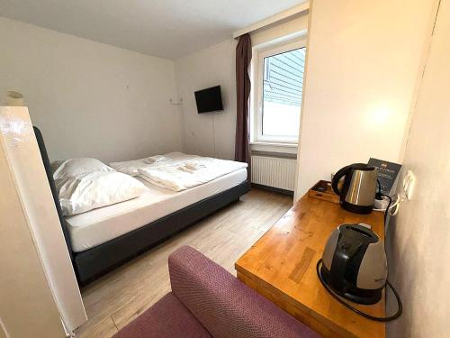 ein kleines Schlafzimmer mit einem Bett und einem Tisch in der Unterkunft M2 Rooms in Lübeck