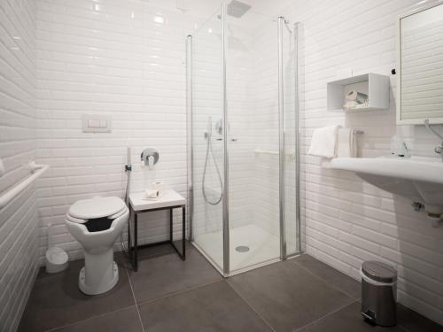 a bathroom with a shower and a toilet and a sink at Glocal Torbole in Nago-Torbole