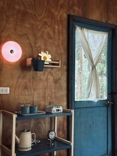 a room with a blue door and a window at Cabin Home อยู่ป่า wild and free in Ko Larn