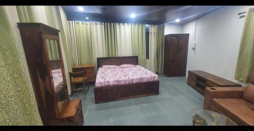 a bedroom with a bed and a desk and a chair at Unwind Farm Retreat in Hyderabad