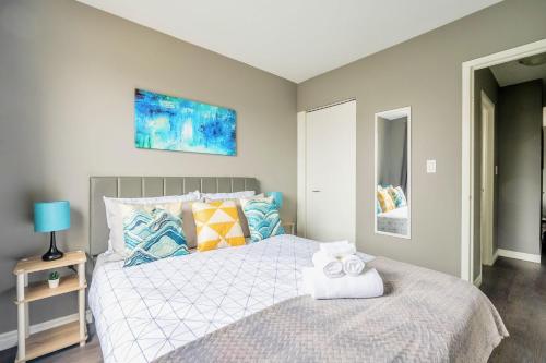 a bedroom with a bed with towels on it at Charming Newly Renovated Condo - Glenview West in Hamilton