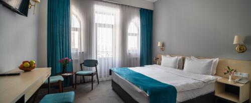 a hotel room with a bed and a desk and chairs at KHIVA RESIDENCE - Eastern Hotel in Khiva