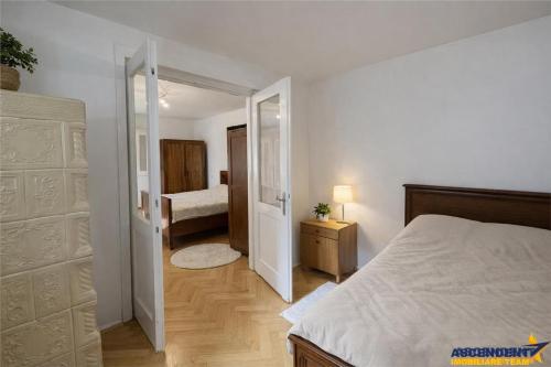 a bedroom with a bed and a door leading to a bathroom at Emese Central Square Vintage Apartment in Târgu-Mureş