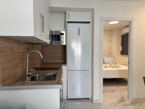 a white kitchen with a sink and a refrigerator at Marco Apartment By Torremolinos On-line in Torremolinos