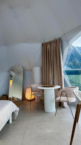 a bedroom with a bed and a table and a window at Les Dômes du Moulin in Urtaca