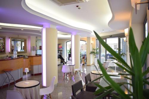 an office lobby with tables and chairs and a plant at Jans e Gracy - Appartamenti e camere in Gabicce Mare