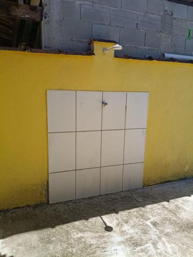 a pair of white garage doors on a yellow wall at Pousada da Tom-Ubatuba Perequê-Açu in Ubatuba