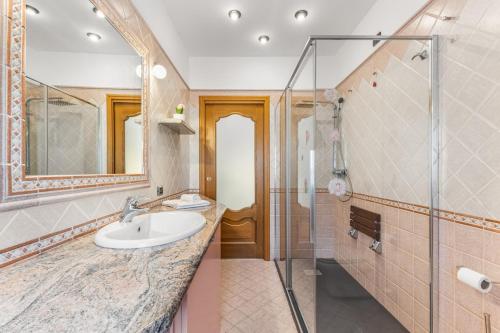 a bathroom with a sink and a glass shower at Large apartment with terrace AC e WiFi in Sesto San Giovanni
