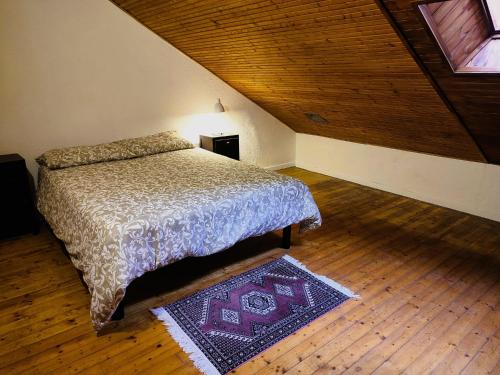 a bedroom with a bed and a wooden ceiling at La Caserma -The Barracks in Bobbio Pellice