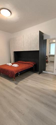 a bedroom with a bed with a red blanket at Monolocale corte in Pavia