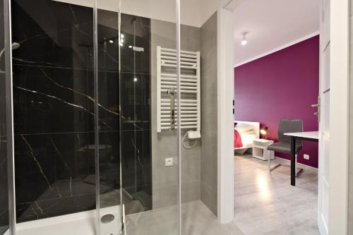 a bathroom with a walk in shower next to a bedroom at LC pokoje & apartamenty B52 in Szczecin