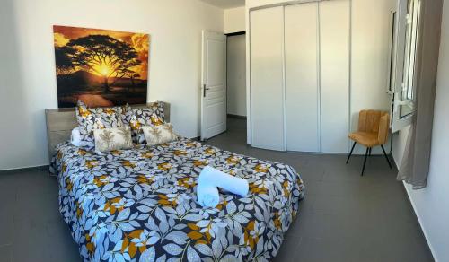 a bedroom with a large bed with a large painting on the wall at Villa Valérie in Bras-Panon