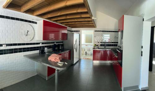 a kitchen with red cabinets and a black counter at Villa Valérie in Bras-Panon