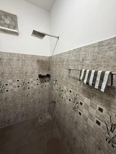 a bathroom with a shower with a towel on a wall at Ayathma Heights in Weligama