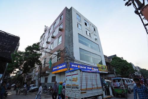 a tall building with a truck parked in front of it at Hotel O Plus One Hotel Residency in New Delhi