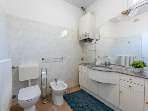 a white bathroom with a toilet and a sink at Giardino del Convento in Domaso
