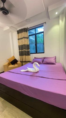 a large purple bed with a swan on it at Ayathma Heights in Weligama