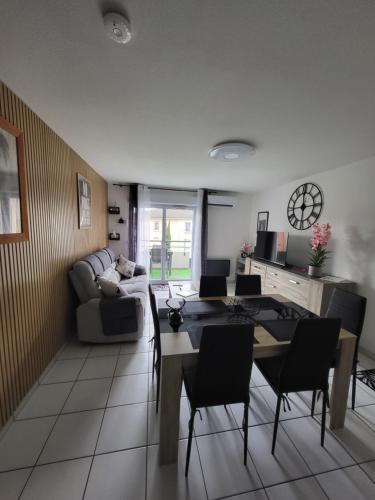 a living room with a couch and a table and chairs at Le Colibri in Fenouillet