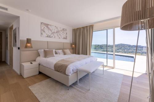 a bedroom with a large bed and a large window at Villa Paulina MOUGINS in Mougins