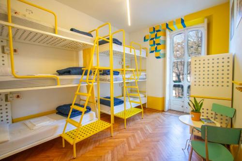 a room with yellow bunk beds and a table at Ostello Bello Lake Como in Como
