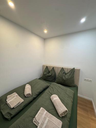 a bedroom with a green bed with three pillows at Black Forest Vista - Pool Sauna Tennis in Schonach