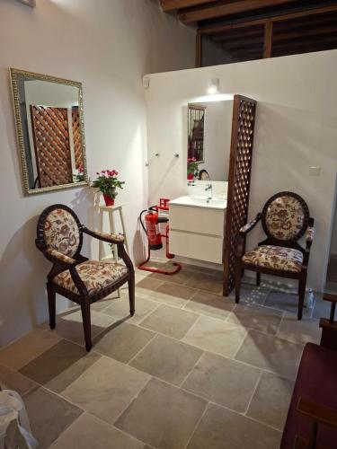 a bathroom with two chairs and a sink at Cecilia Traditional House-Suites in Kalopanayiotis