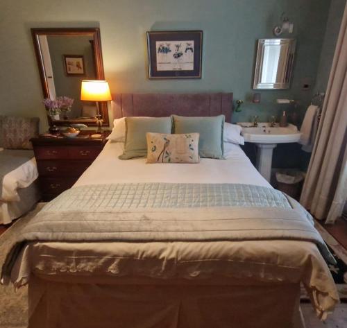 a bedroom with a large bed and a sink at Maybank Guest House in Helensburgh