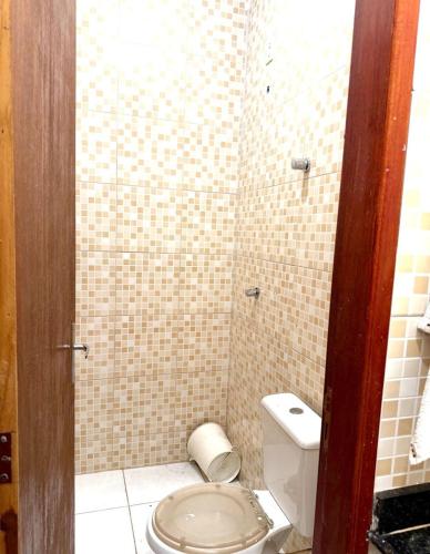 a bathroom with a toilet and a tiled shower at Cond Cristo Redentor in Trindade