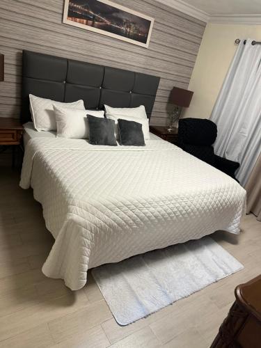 a bedroom with a large bed with white sheets and pillows at Elevate View Penthouse in Santo Domingo