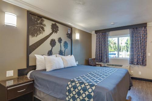 a hotel room with a bed and a window at Hotel Seville - Ontario Airport/Chino in Ontario