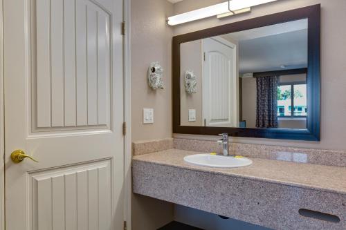 a bathroom with a sink and a mirror at Hotel Seville - Ontario Airport/Chino in Ontario