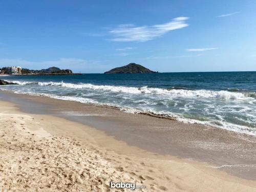 a sandy beach with waves in the ocean at Departamento con vista al mar, Marina del sol-Zona Cerritos in Mazatlán
