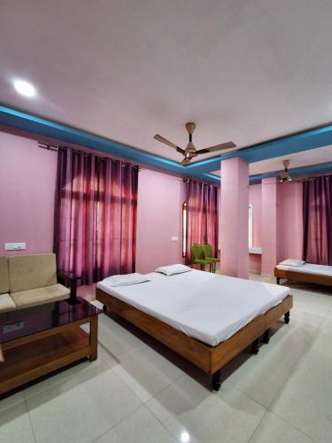 a bedroom with a large bed and a couch at Hotel New Castle in Guwahati