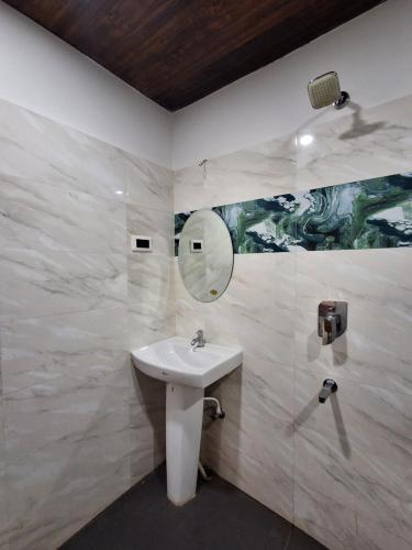 a bathroom with a sink and a mirror at Hotel New Castle in Guwahati
