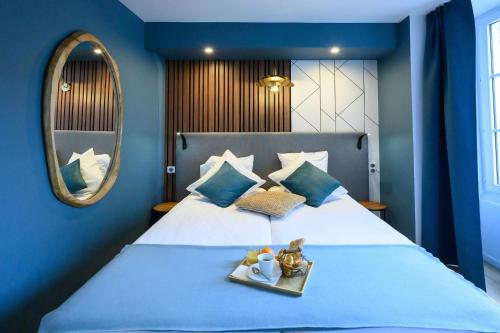 a blue bedroom with a bed with a tray of food at L'Esplanade Hôtel Restaurant Bar à vin in Le Pellerin