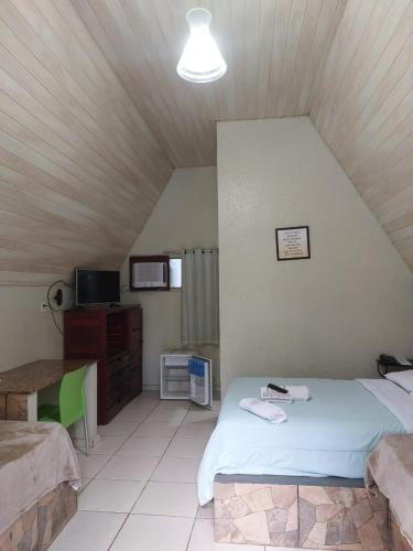 a bedroom with a bed and a desk in a room at Samaúma Park Hotel in Barcarena