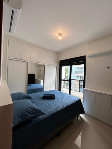 a bedroom with a large bed and a large window at Apê Ásia in Governador Celso Ramos
