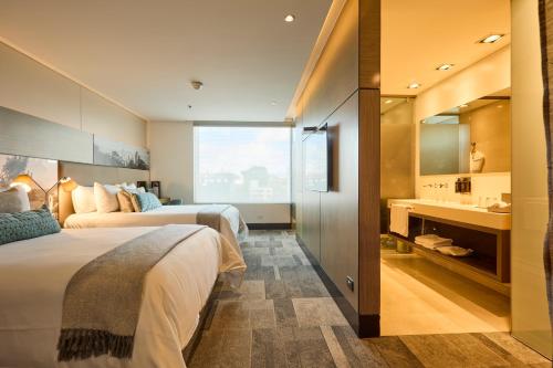 a hotel room with two beds and a sink at EK Hotel By Preferred Hotels Group in Bogotá