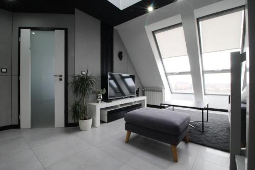 a living room with a television and a chair at Bulwar Apartament in Głogów