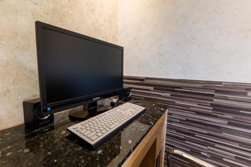 a computer monitor and a keyboard on a desk at Boutique Hotel SB Yeouido in Seoul