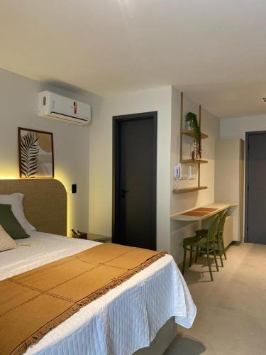 a bedroom with a bed and a table and a desk at FLAT Intermares HUB 105 in Cabedelo