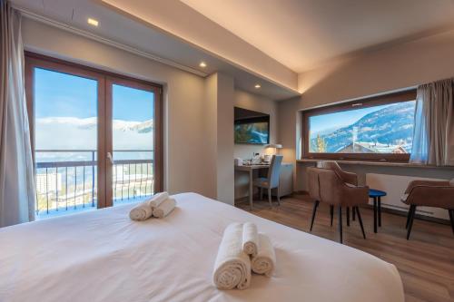 a hotel room with a large bed with two towels at Lift Hotel in Sauze dʼOulx